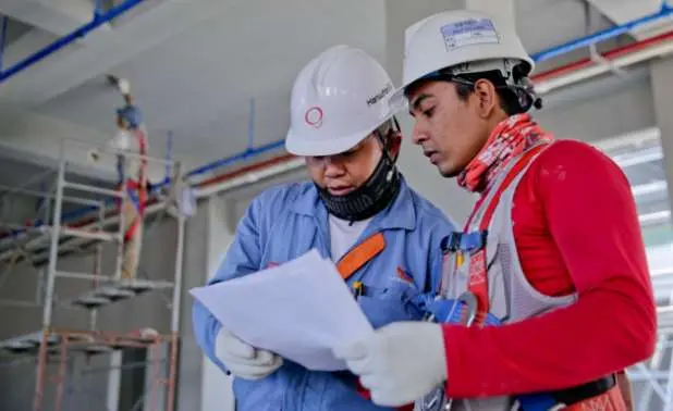 Two industrial workers looking at a paper